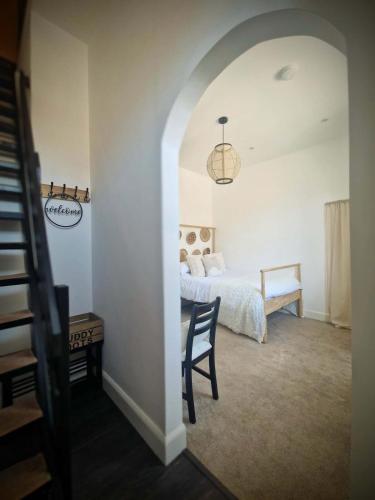 a bedroom with a bed and a table and a chair at Stone Cottage Relax & Unwind, Cosy Cinema Retreat in Laurencekirk