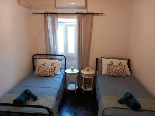 two twin beds in a small room with a window at Belvedere di Van D'oro 1886 in Peroulades