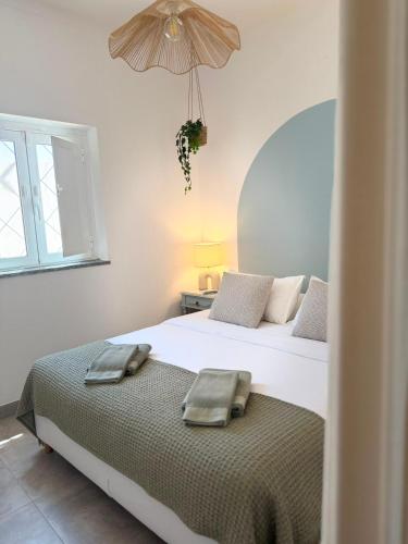 a bedroom with two beds and an umbrella at Quinta Do Priorado in Moncarapacho