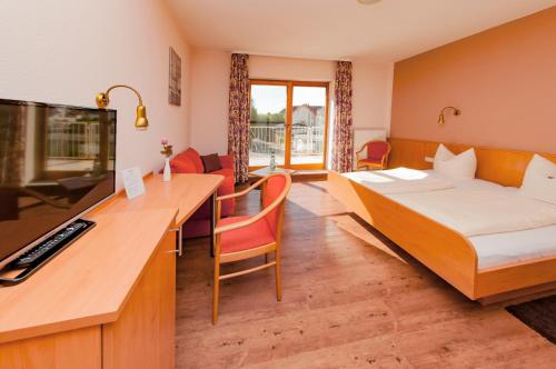 a hotel room with a bed and a desk at Hotel Bett & Frühstück in Riedstadt