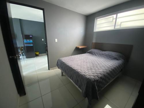 a bedroom with a bed and a sliding glass door at Hermoso Departamento Ejecutivo 2 in Guadalupe