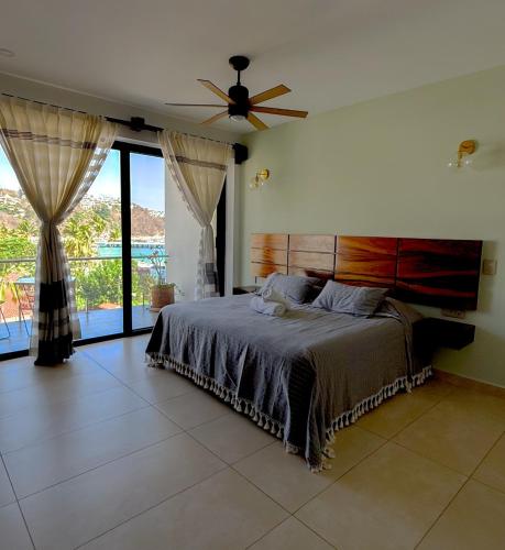 a bedroom with a bed and a ceiling fan at EOS Suites in Santa Cruz Huatulco