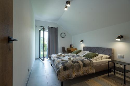 a bedroom with a bed and a table and a window at Nowa Osada in Łącko