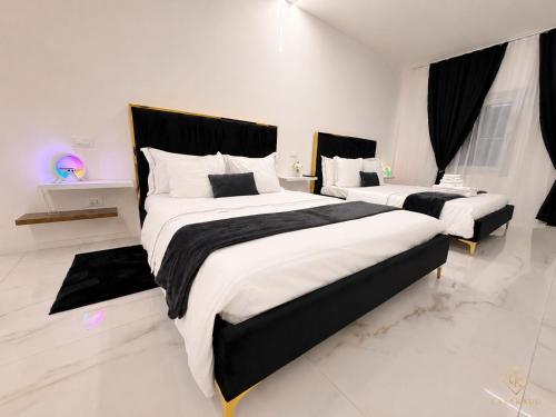 two beds in a white room with black and white at CasaKadd Grand Escape in Civé