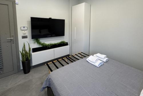 a white room with a tv and a bed with towels at Date Palm Studio in Kremasti