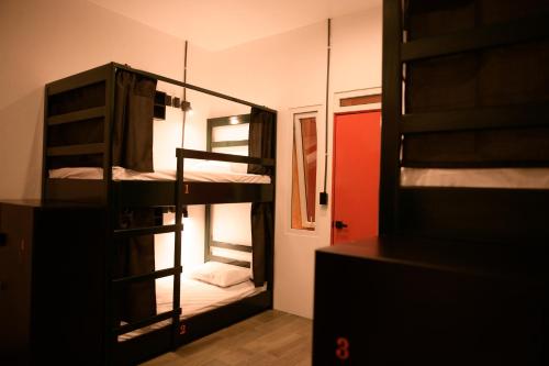 a room with three bunk beds and a mirror at Macarena Hostel in Flores