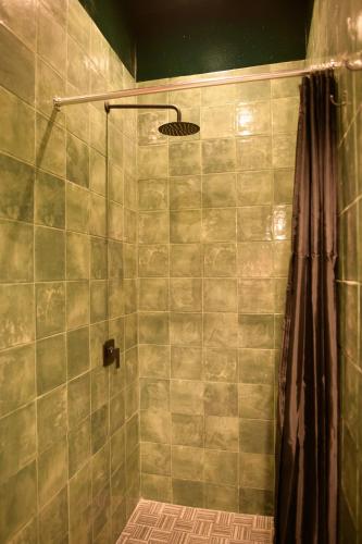 a bathroom with a shower with a shower curtain at Macarena Hostel in Flores