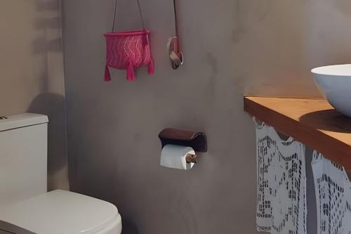 a bathroom with a toilet and a roll of toilet paper at Casa Capela - Para quem ama ficar na beira do mar in Marau