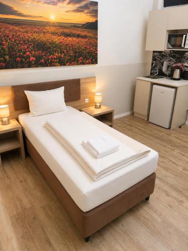 a bedroom with a bed with a painting on the wall at Aparthotel Emilia 24h Check-in, Free Parking and WiFi in Bargteheide