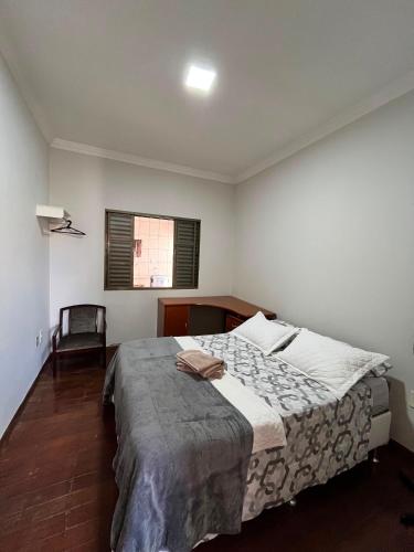 a bedroom with a large bed in a room at Casa Completa à 100m do Parque de Exposição in Patos de Minas