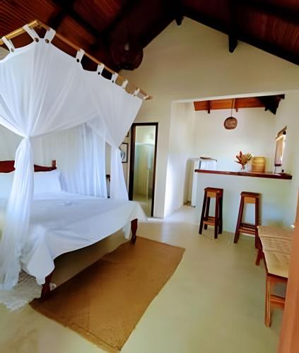 a bedroom with a large bed and a table at Licuri Praia de Algodões paz amor na beira do mar in Marau