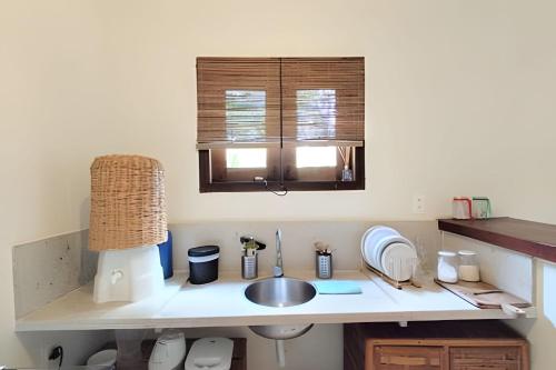a kitchen counter with a sink and a window at Licuri Praia de Algodões paz amor na beira do mar in Marau