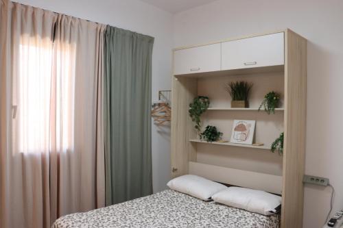 a bedroom with a bed and a cabinet with plants at Estudio Puerto Isla in Isla Cristina
