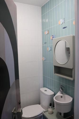 a bathroom with a toilet and a sink and a mirror at Estudio Puerto Isla in Isla Cristina