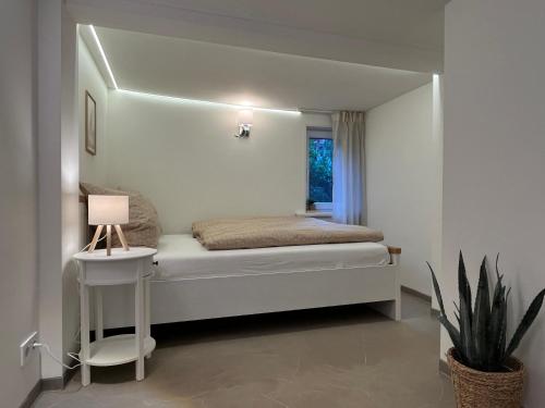 a bedroom with a bed with a lamp and a plant at Ferienhaus an der Eder in Edertal