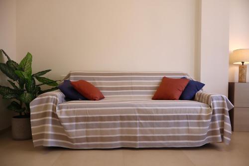 a couch with two pillows on it in a living room at Casa Riviera Chiara con Parcheggio Privato nel Cuore di Arma in Arma di Taggia