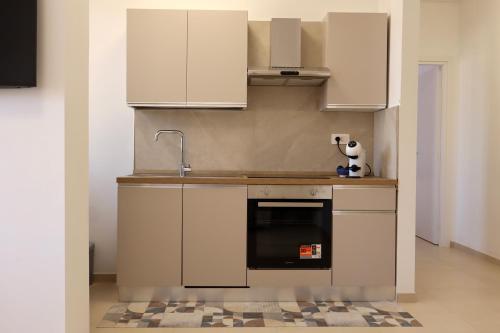 a kitchen with white cabinets and a black oven at Casa Riviera Chiara con Parcheggio Privato nel Cuore di Arma in Arma di Taggia