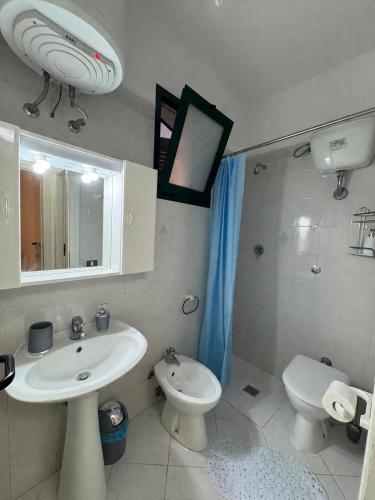 a bathroom with a sink and a toilet and a mirror at Salento Holiday Home in Torre Inserraglio