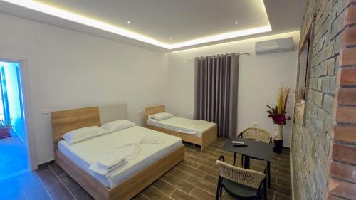 a bedroom with a bed and a table and a chair at Vila Qetesia in Përmet