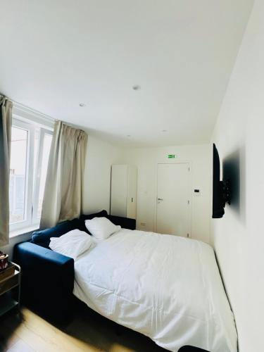 a bedroom with a white bed and a blue couch at Le Cocon in Brussels