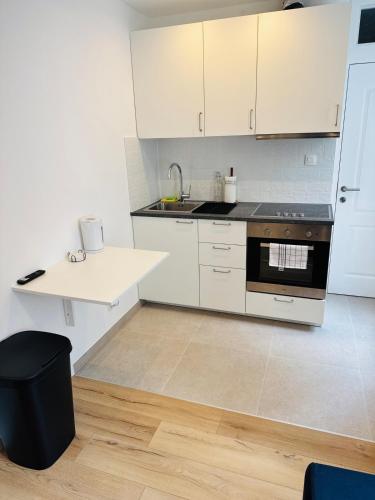 a kitchen with white cabinets and a stove top oven at Le Cocon in Brussels