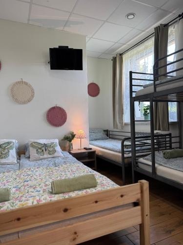a bedroom with two bunk beds and a television at Pokoje Tanie Spanie in Zator