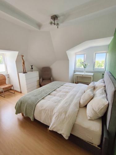 a bedroom with a large bed and two windows at Ressel Mansion in Bitterfeld