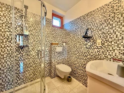 a bathroom with a shower and a toilet and a sink at Lavanda Vendégház in Németkér