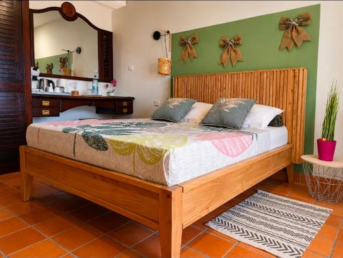 a bedroom with a wooden bed with a mirror at Studio vue sur la mer, piscine - L'Oasis de Tartane in La Trinité