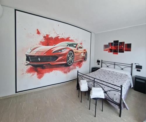a bedroom with a painting of a car on the wall at Damhomeitaly in Modena
