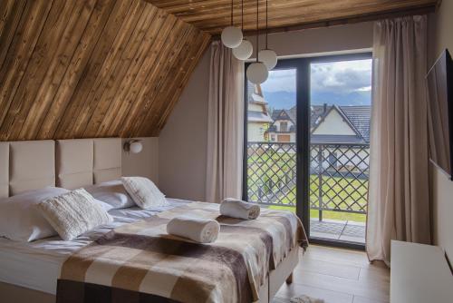 a bedroom with a large bed and a large window at Stacja Tatry in Poronin