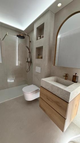 a bathroom with a sink and a toilet and a mirror at Havre de paix avec jacuzzi in Grône