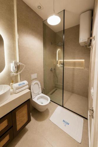 a bathroom with a shower and a toilet and a sink at Delor Studio Drymades,Santorini in Dhërmi