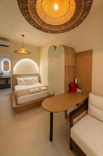 a bedroom with a bed and a wooden table at Delor Studio Drymades,Santorini in Dhërmi