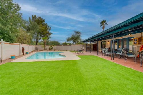 a backyard with a swimming pool and green grass at Private Tucson Oasis with Pool & Large Backyard in Tucson