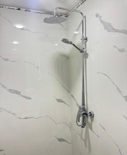 a shower in a bathroom with white marble at Ahmed sarii in Asilah