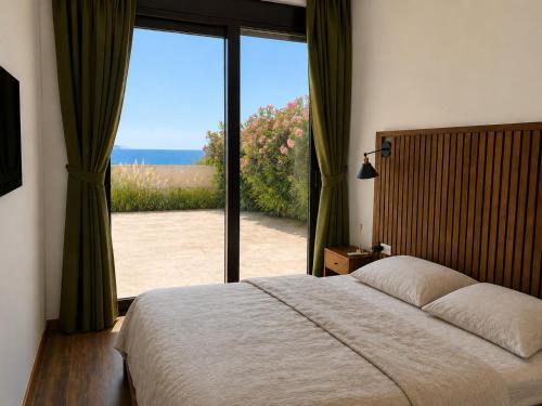 a bedroom with a large bed and a large window at Sunset Vista Sonnenuntergang mit Jacuzzi und Sauna in Katun
