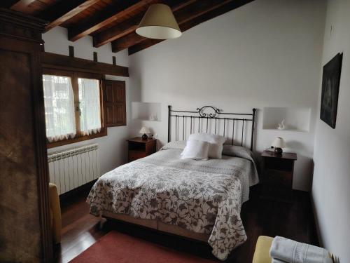 a bedroom with a bed with a white blanket and a window at Cristeta2 in Medina de Pomar