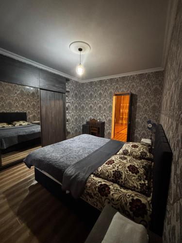a bedroom with a large bed and a window at Uplistsikhe guest "Paluma" in Kʼvakhvreli