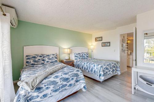 two beds in a room with green walls at MA221 The Tropical Cove 329 in Marathon