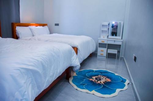a bedroom with two beds and a table with a mirror at Wete View Hotel in Wete