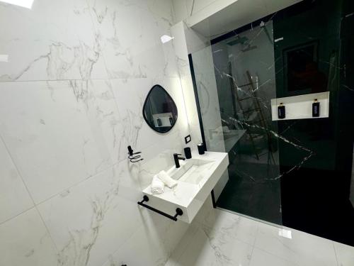 a white bathroom with a sink and a mirror at Le Dimore Airport Luxury in Bari