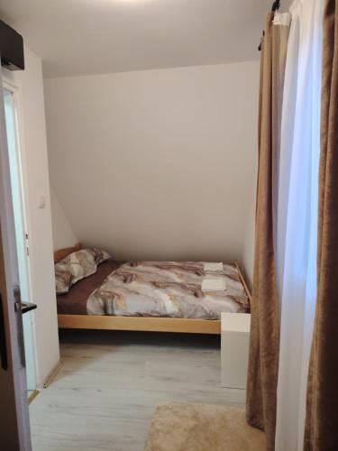a bedroom with a bed in the corner of a room at Vikendica na Jazu in Kosjeric