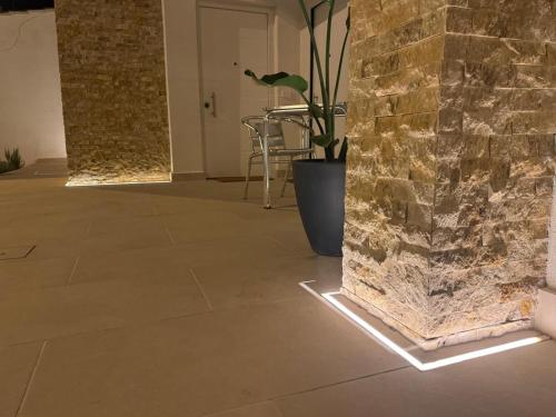a room with a stone wall with a light on the floor at Le Dimore Airport Luxury in Bari