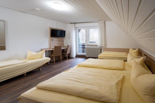a hotel room with three beds and a desk at Grüner Hof in Zell am Harmersbach