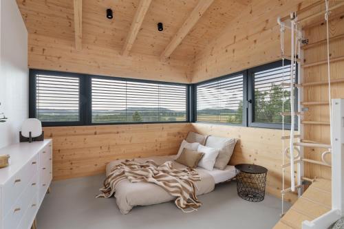 a bedroom with a bed in a room with wooden walls at Sauna House Zelené Údolí in Rabyně