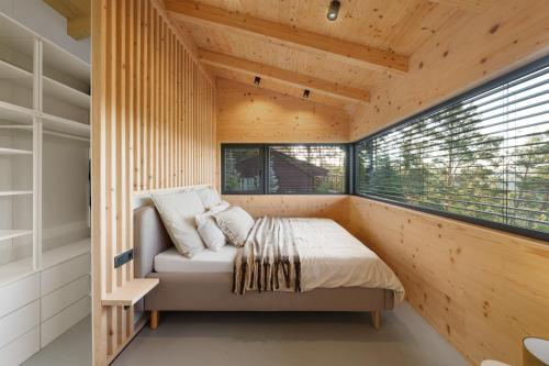 a bedroom with a bed in a room with a window at Sauna House Zelené Údolí in Rabyně