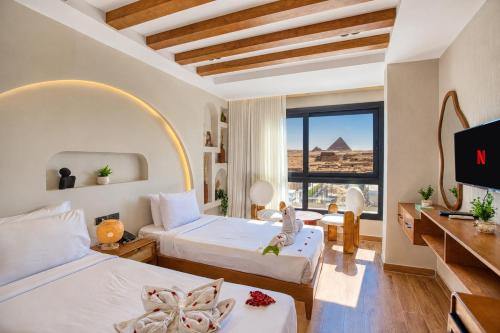 a bedroom with two beds and a view of the pyramids at PANORAMA view pyramids in Cairo