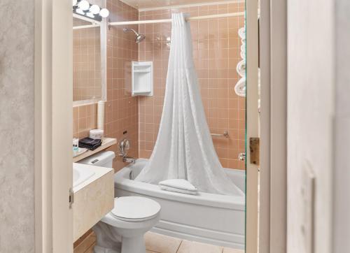 a bathroom with a tub and a toilet and a sink at Bow View Lodge in Banff
