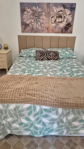 a bed in a bedroom with a bedspread and pillows at Quarto próximo ao Lago do Major in Atibaia